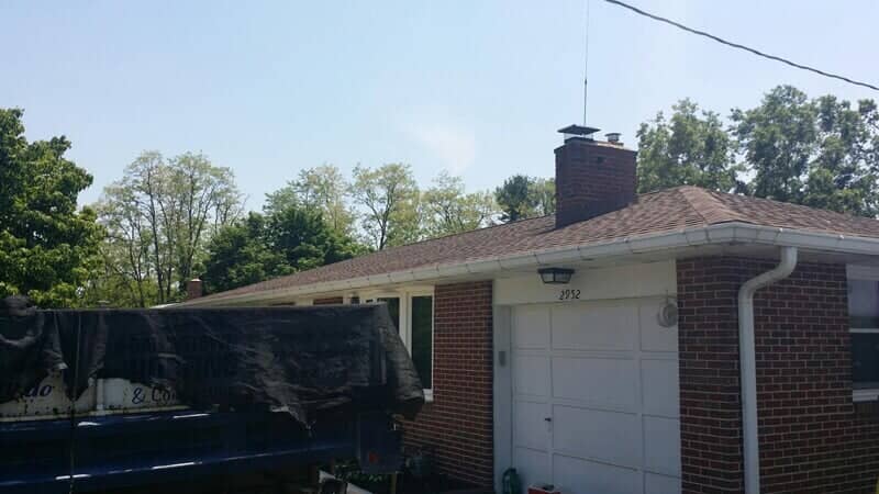 Brick ranch with a new dark shingle roof and Dallastown work truck on-site