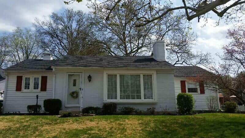 White painted Cape Cod with grey shingle roof and red shutters