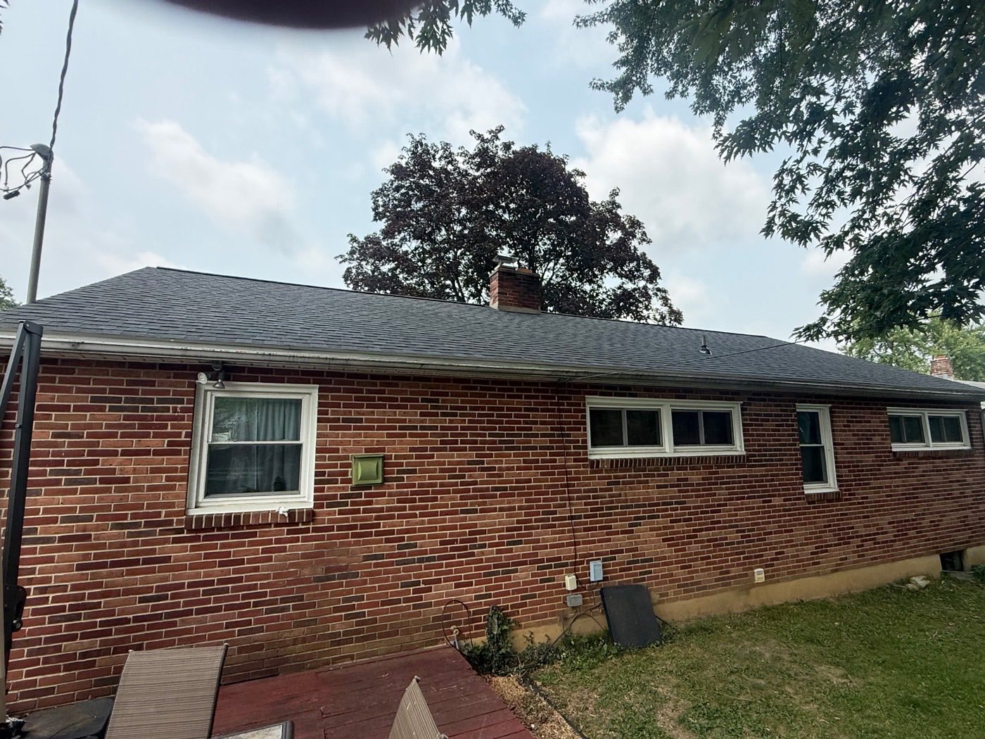 Brick ranch home with a new charcoal architectural shingle roof and brick chimney