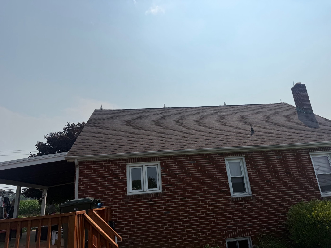 Brick two-story home with a new tan architectural shingle roof and a rear deck in York County, PA