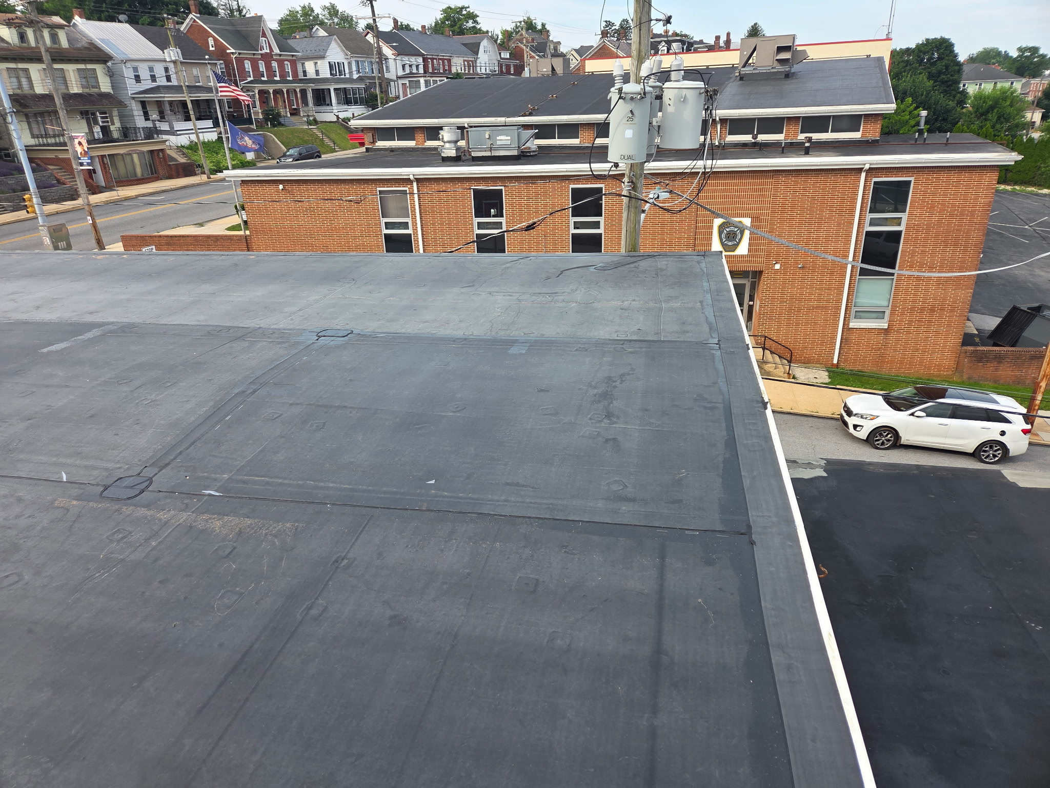 Flat EPDM rubber roof on a brick commercial building next to a firehouse in York County, PA