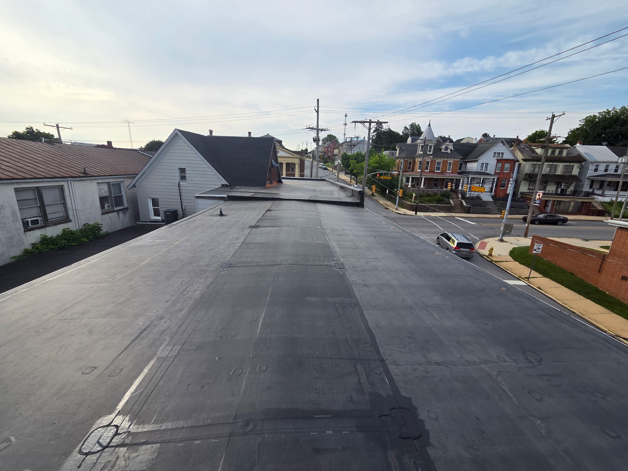 Long run of newly installed black EPDM rubber roofing on a downtown York County commercial building overlooking the street